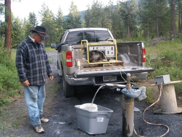 man standing with generator on a pickup truck